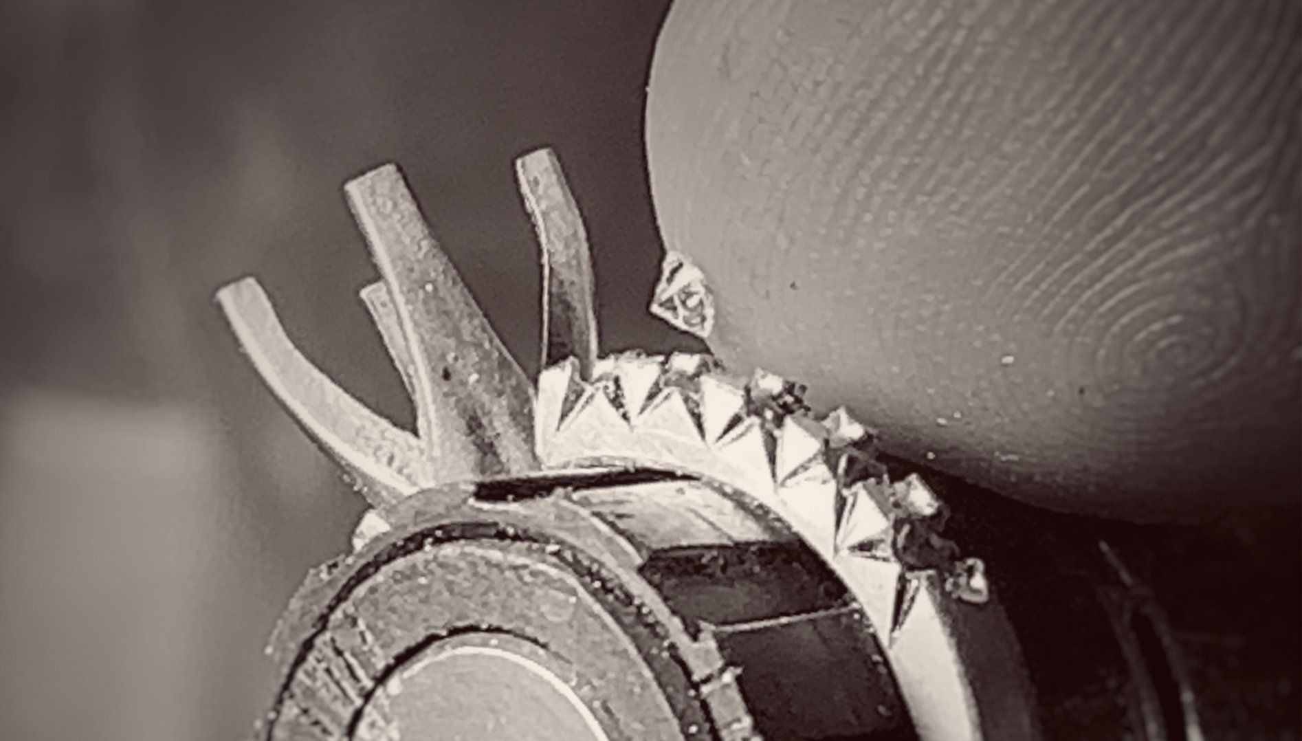 A person is holding a piece of metal on their finger.