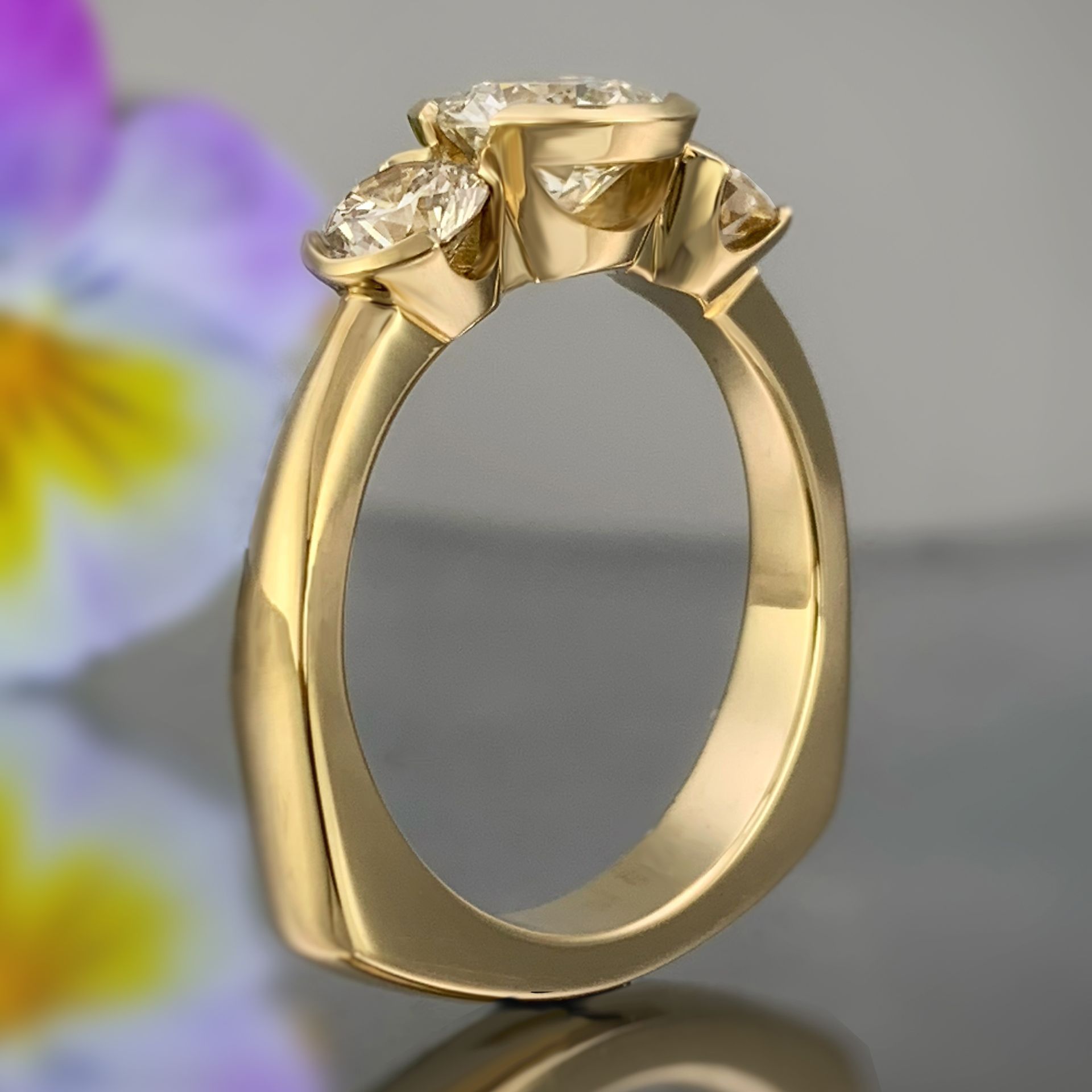 A yellow gold ring with three diamonds on it
