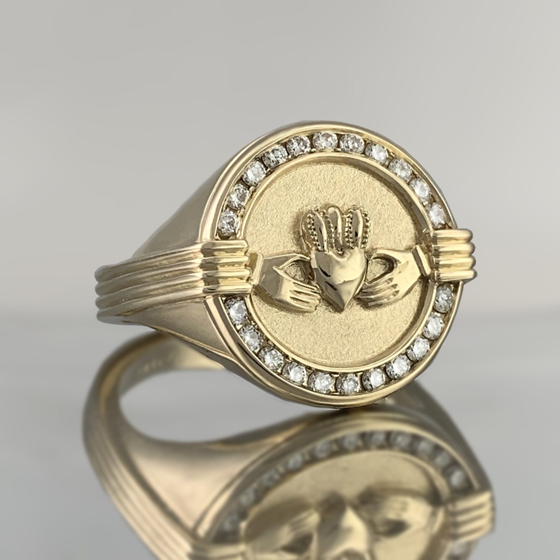 A gold ring with two hands holding a heart