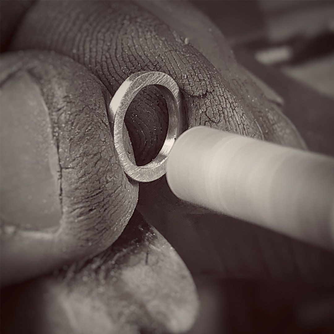 A black and white photo of a person making a ring.