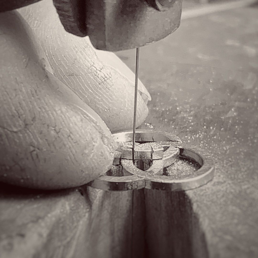 sawing a gold pendant by hand