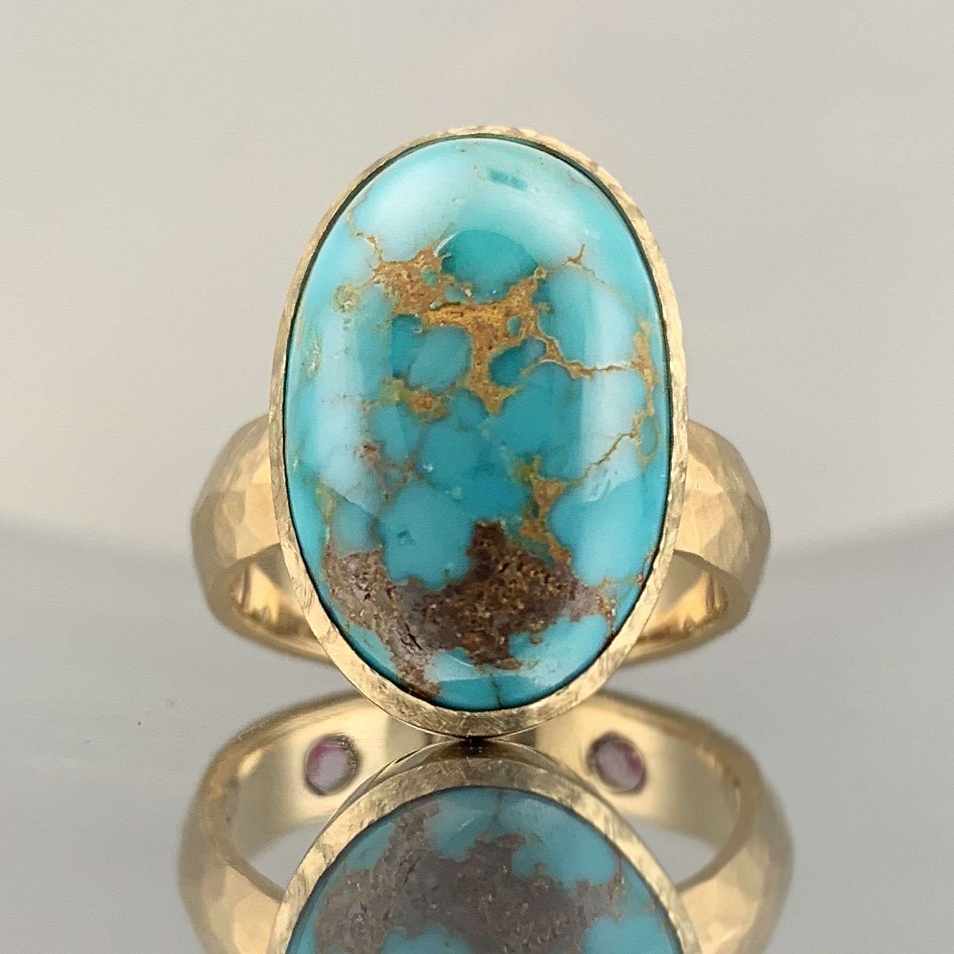 A gold ring with a turquoise stone in the center