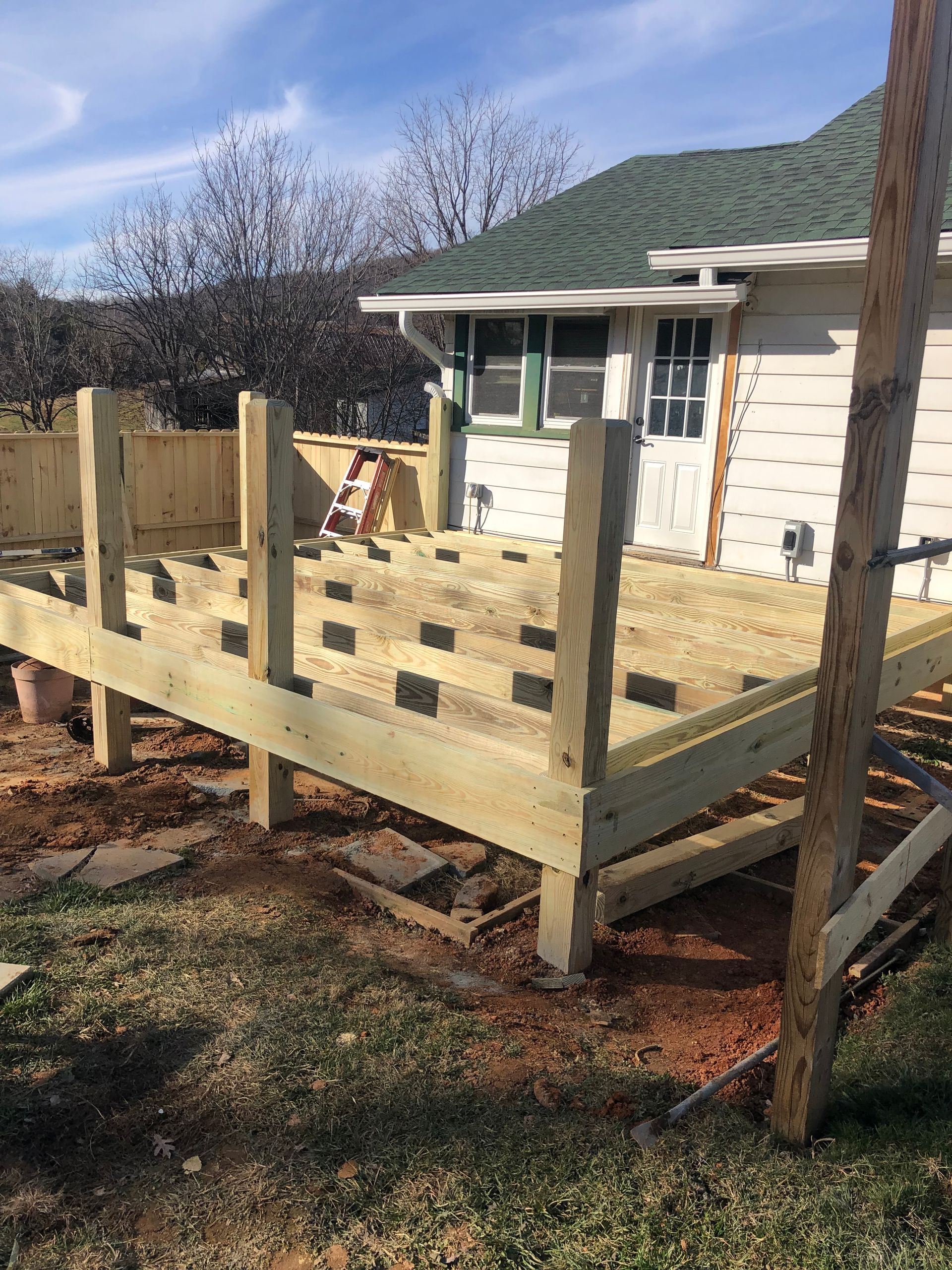A wooden deck is being built in front of a house.