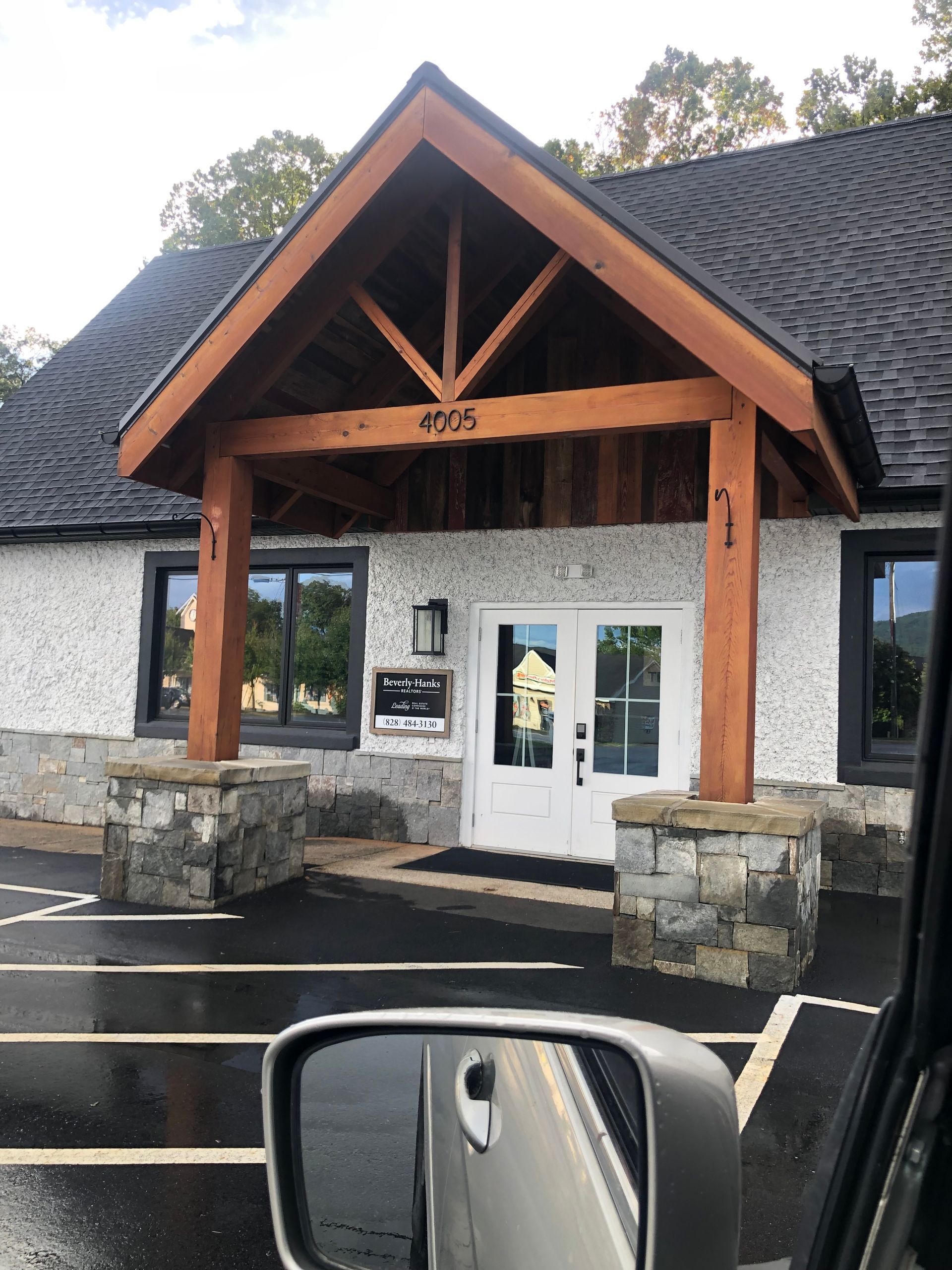 A car is parked in front of a building with the number 8024 on it