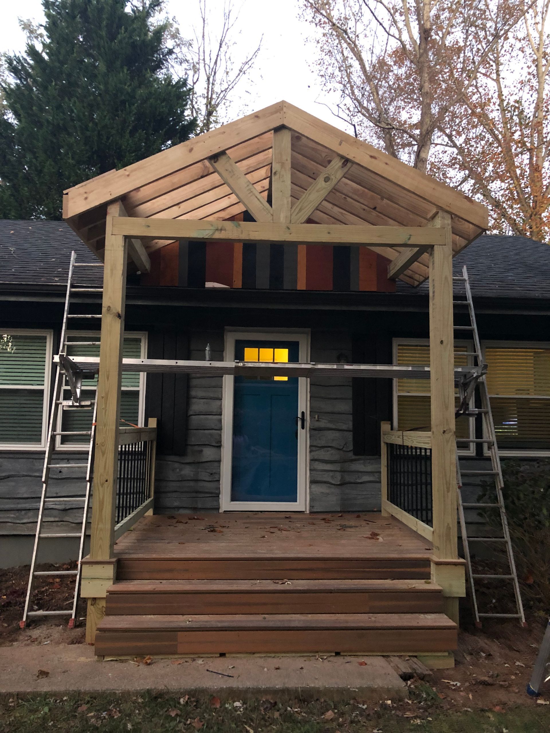 A wooden porch is being built on the front of a house.
