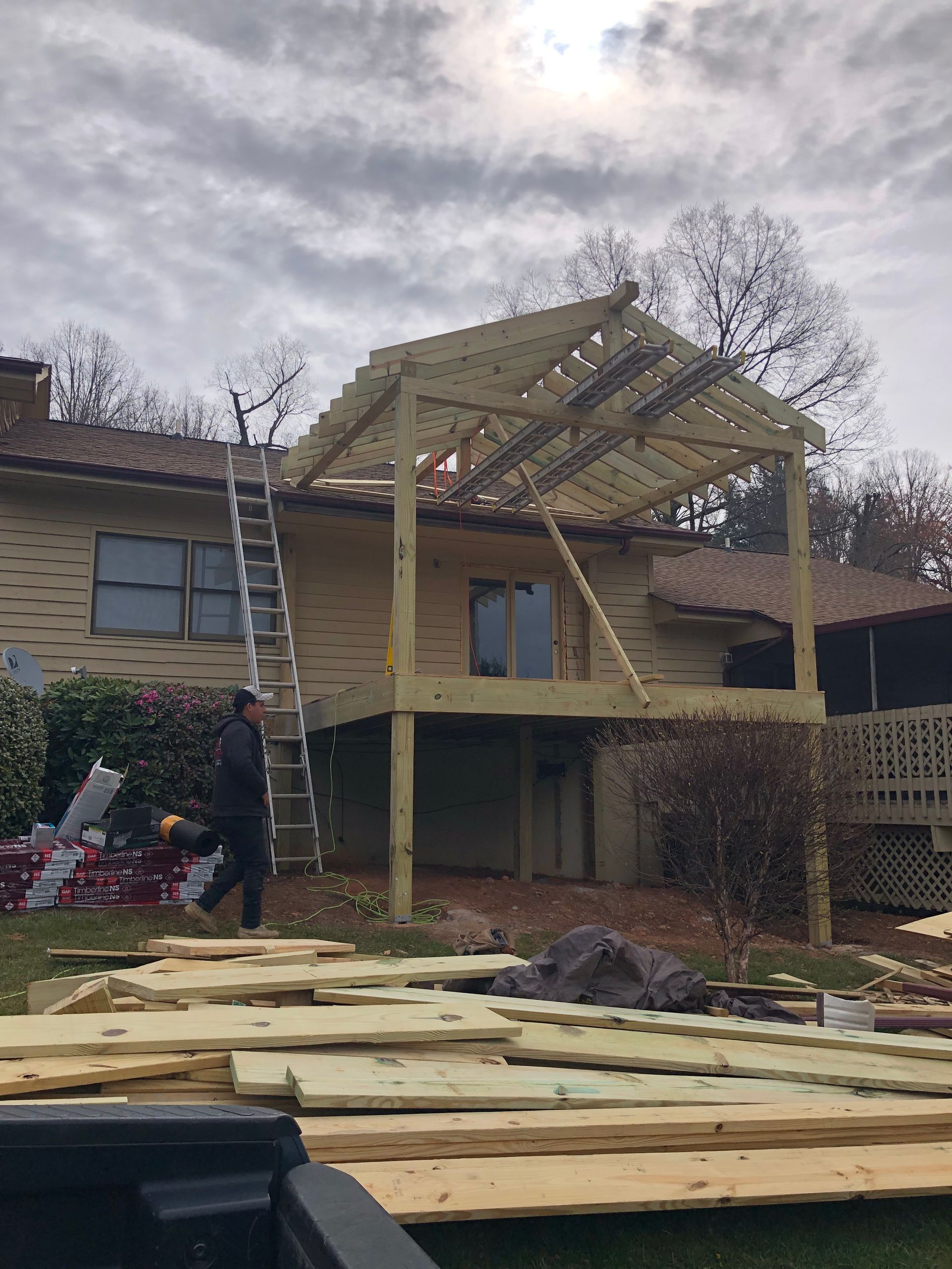 A wooden deck is being built in front of a house.