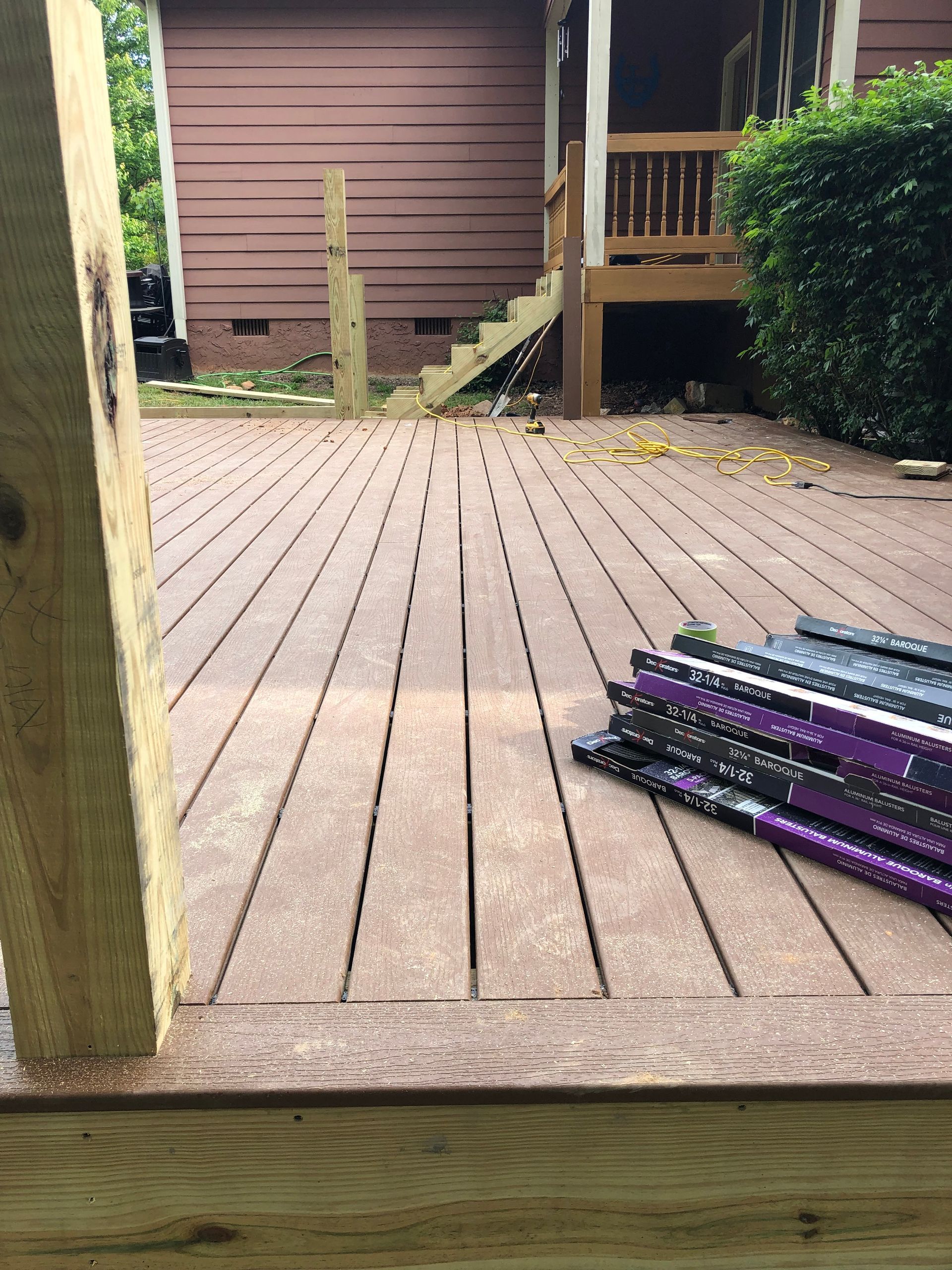 A wooden deck with a stack of purple pencils on it.