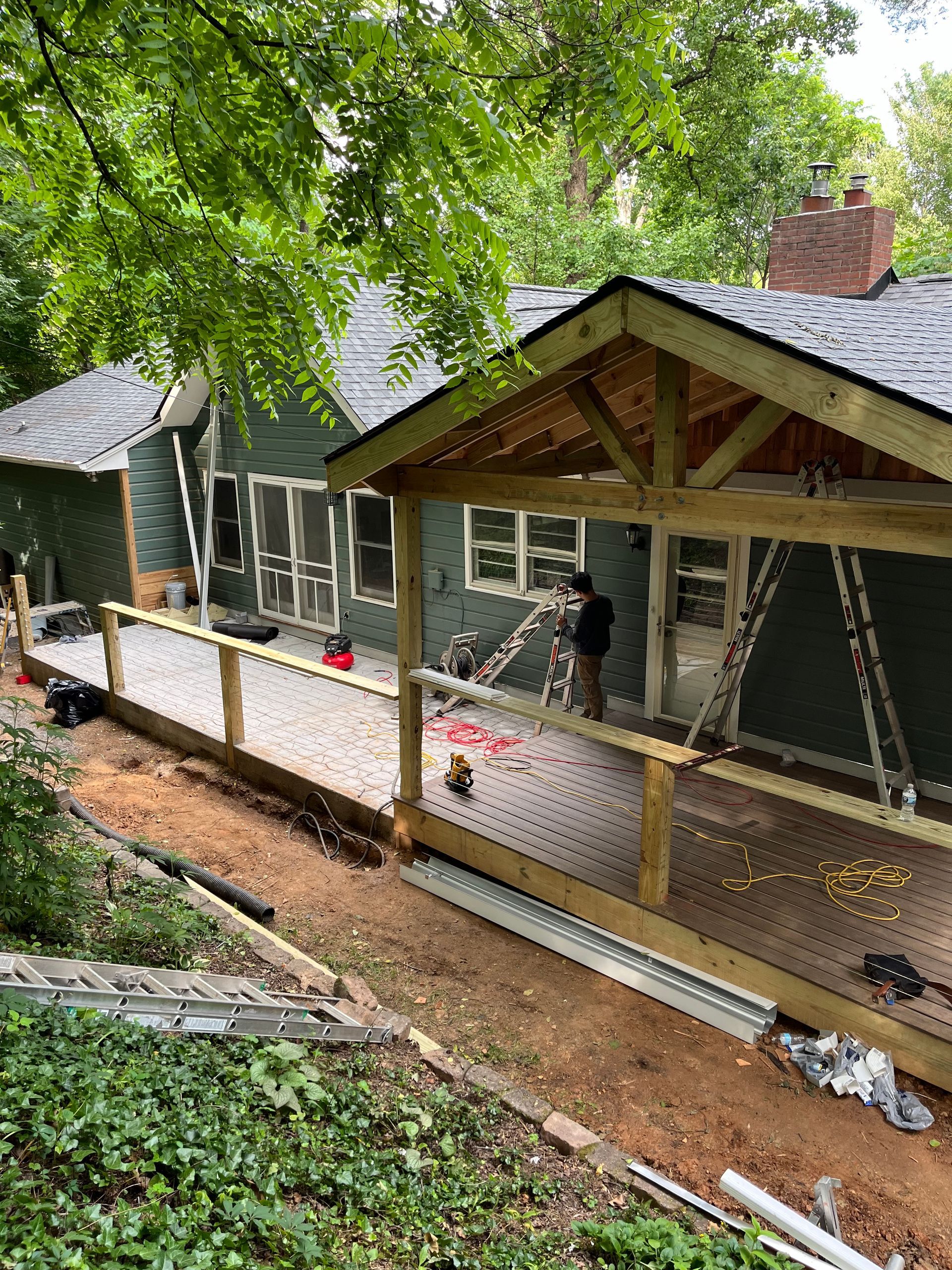 A wooden deck is being built in front of a house.