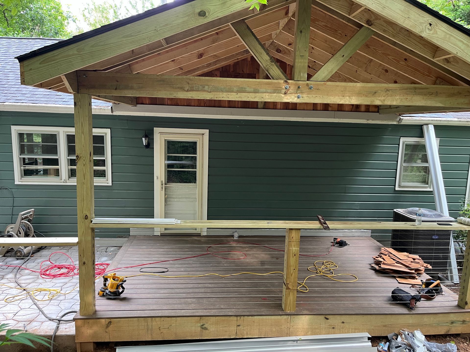 A wooden deck is being built in front of a house.