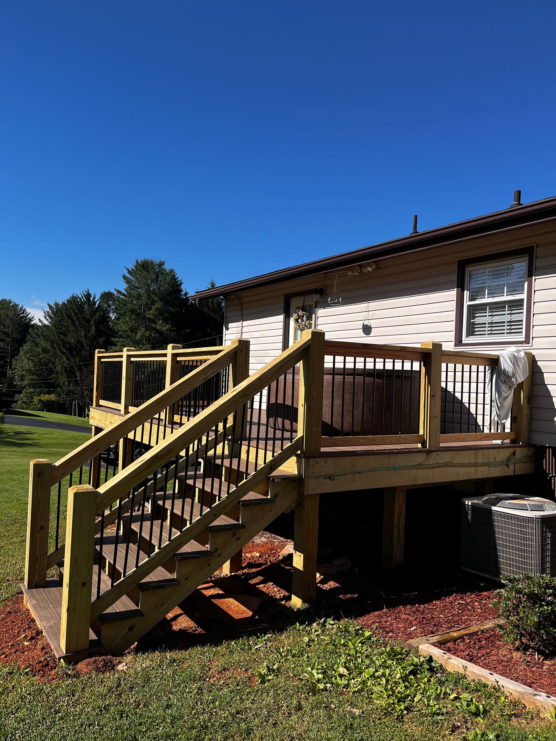 A house with a wooden deck and stairs leading up to it