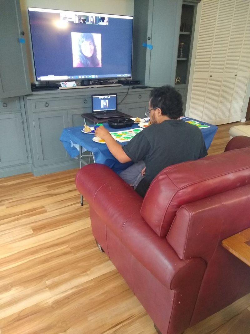 Boats docked in a harbor, city buildings in the background, with red, gray, and turquoise hues.