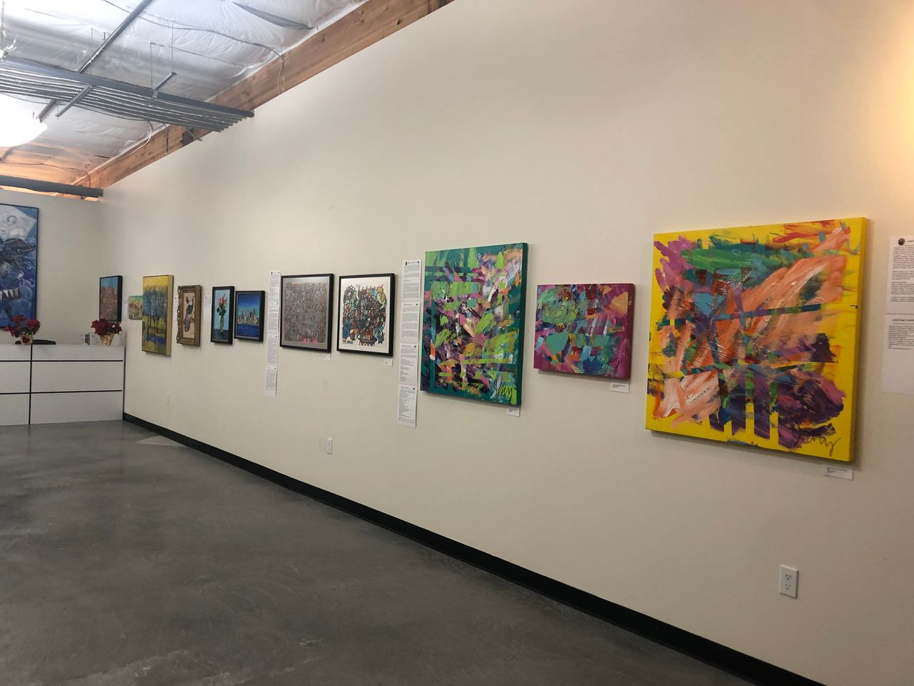 German Shepherd dog with colorful fur in front of a red-and-white striped awning and a building with 