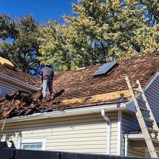 A group of people are working on the roof of a house.