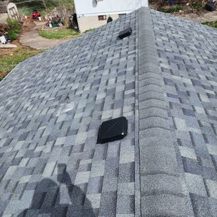 A roof with a lot of shingles on it and a blue sky in the background.