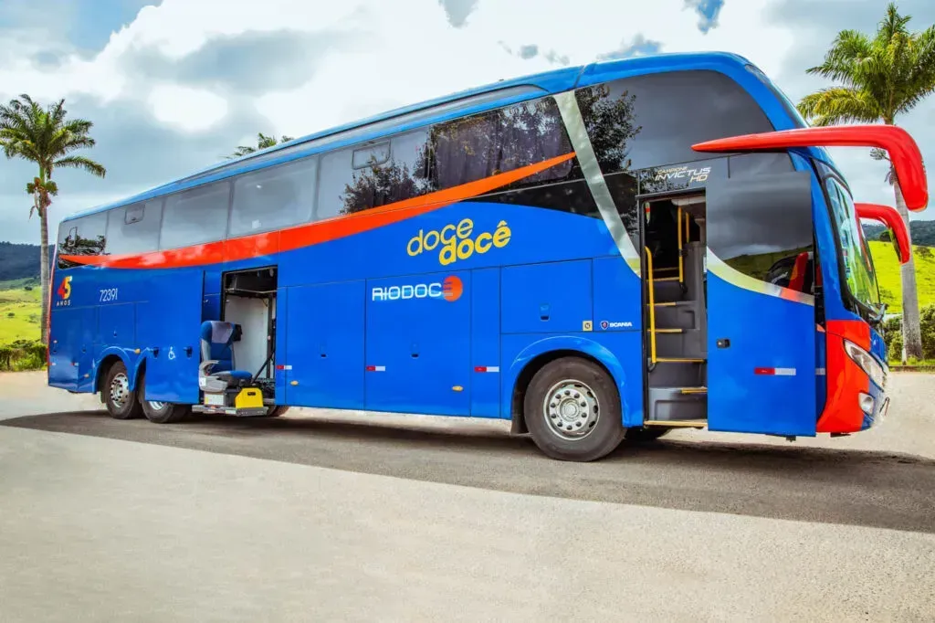 Um ônibus azul e vermelho está estacionado na beira da estrada.