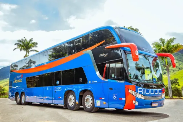 Um ônibus da Rio Doce de dois andares está estacionado na beira da estrada.