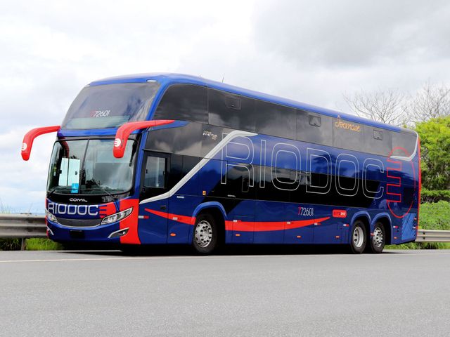 Um ônibus da Rio Doce de dois andares está estacionado na beira da estrada.