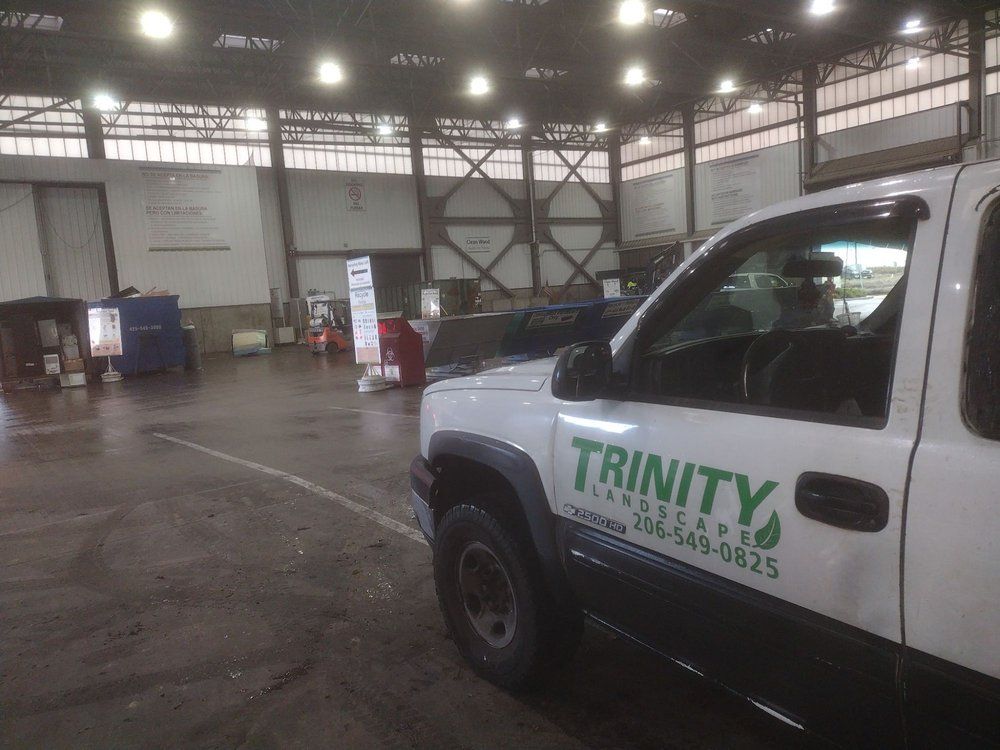 White Trinity Landscaping truck parked inside a large warehouse.