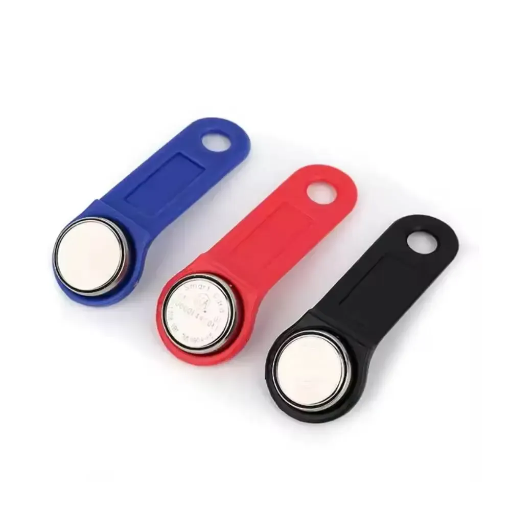 Three different colored key fobs are sitting on a white surface