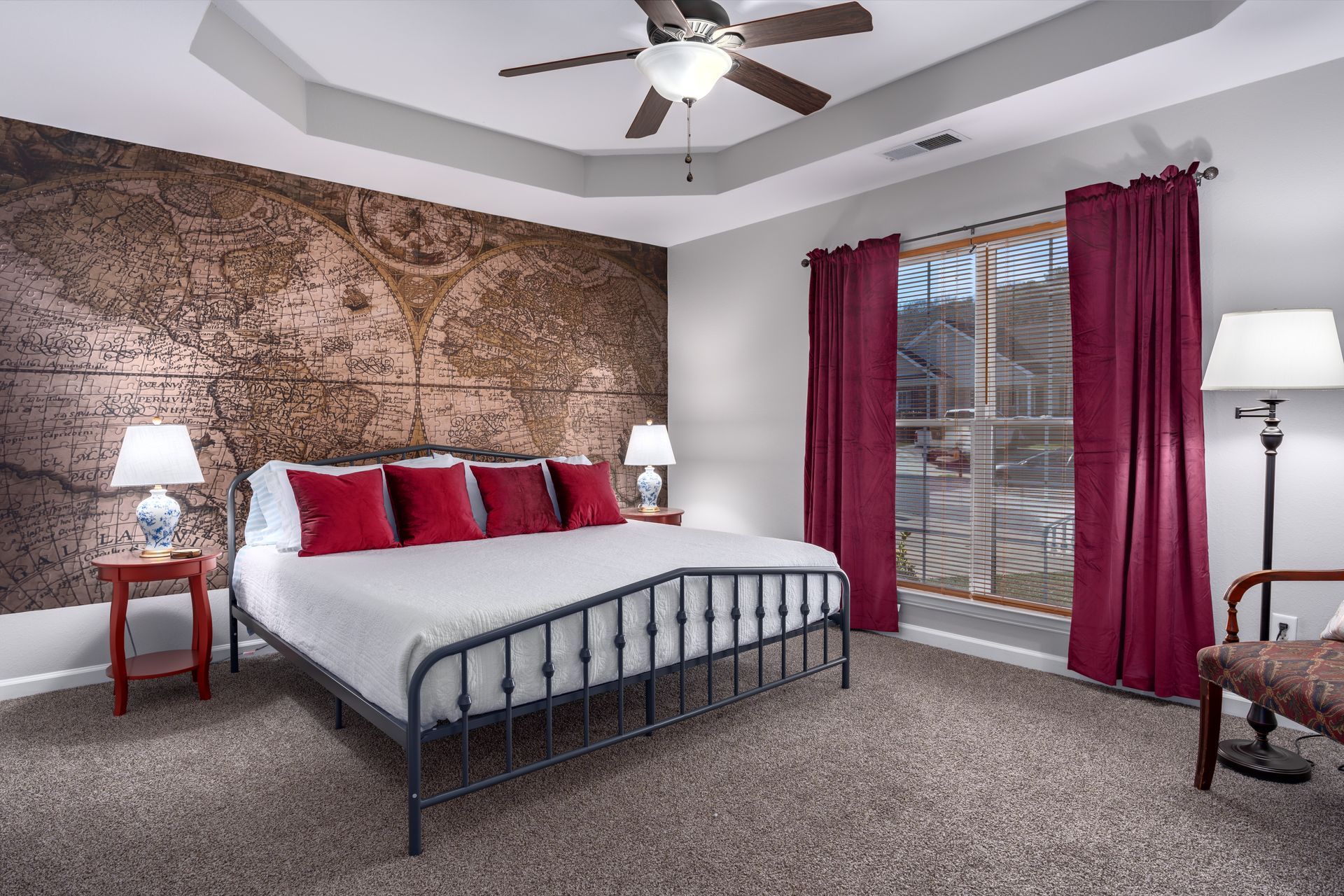 A bedroom with a king size bed and a ceiling fan.