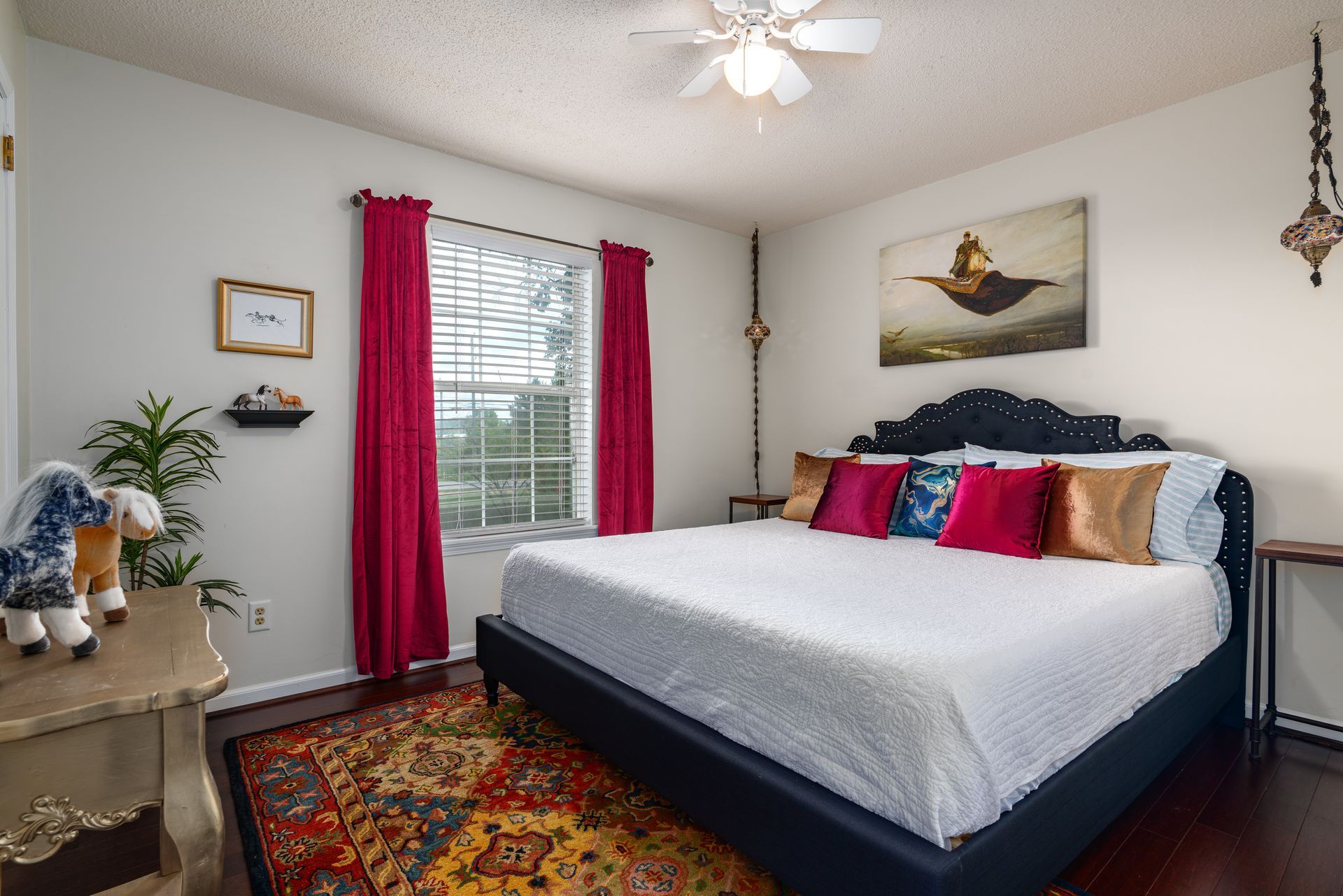A bedroom with a king size bed and a ceiling fan.