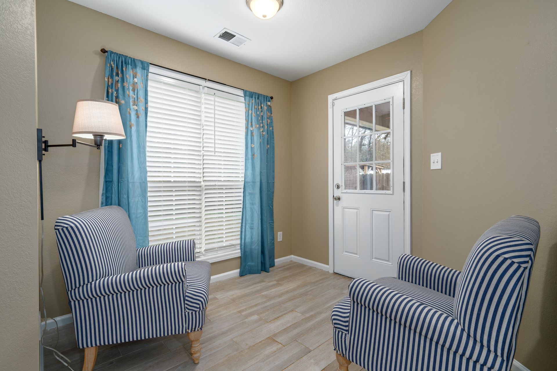 A living room with two chairs and a lamp.