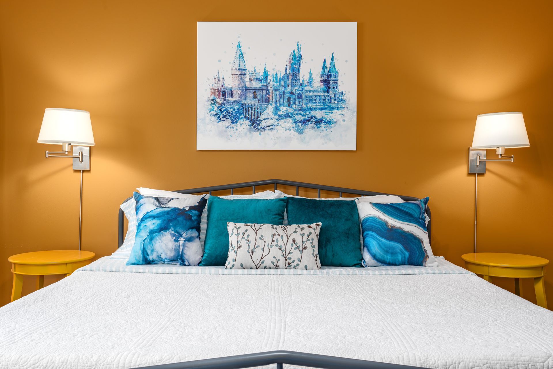 There is a painting on the wall above the bed.