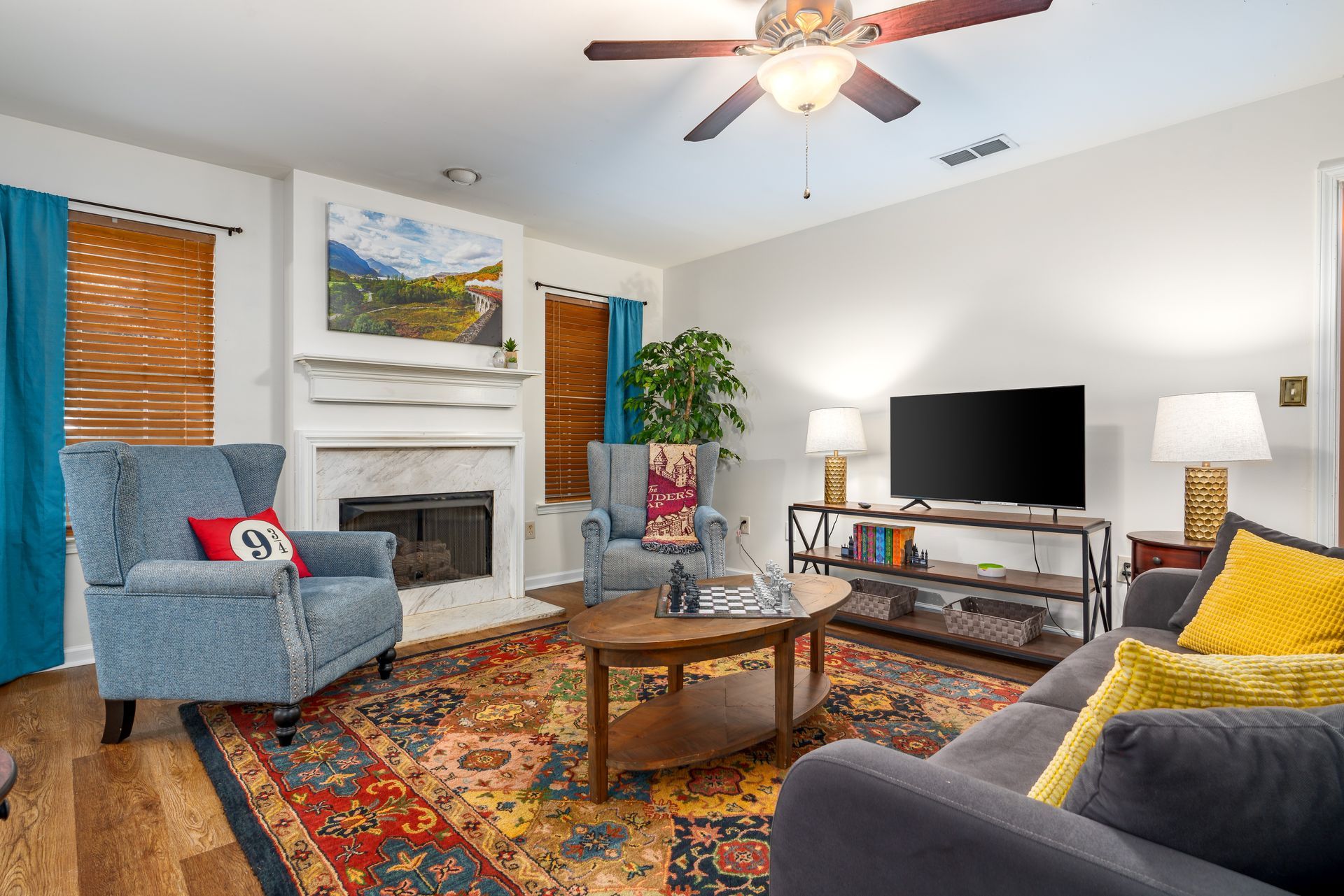 A living room with a couch , chair , coffee table , television and fireplace.
