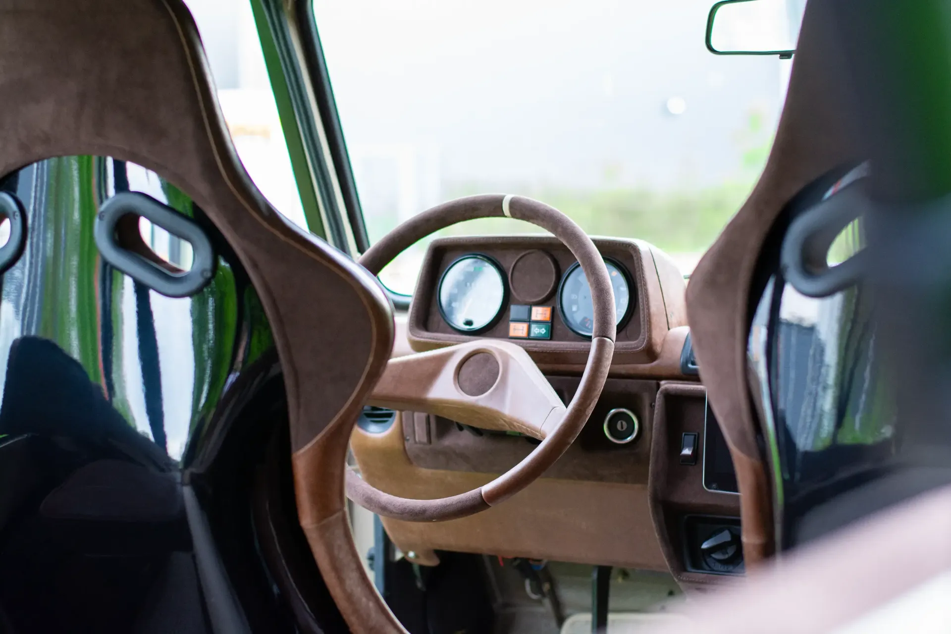 The interior of a car with a steering wheel and seats.