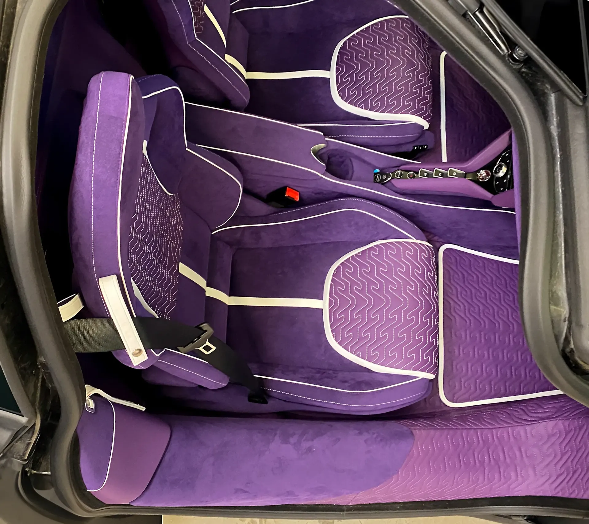 The inside of a purple car with purple seats, McLaren interior