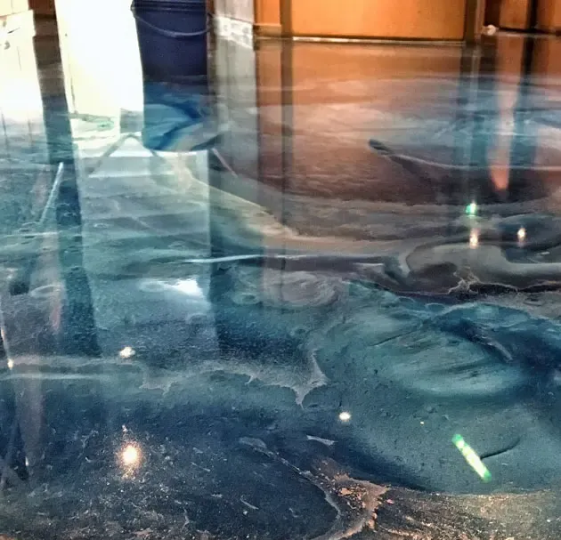 Blue and white swirling epoxy floor, creating an ocean-like effect with reflections.