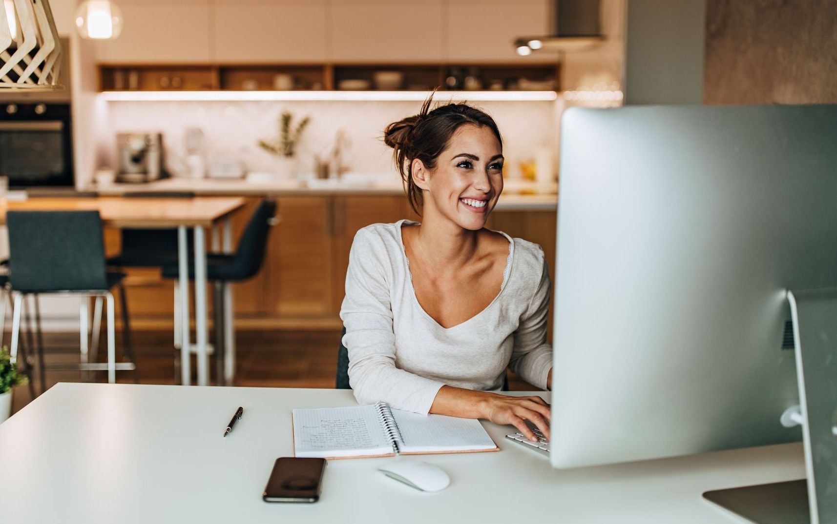 A woman is sitting at a desk in front of a computer.