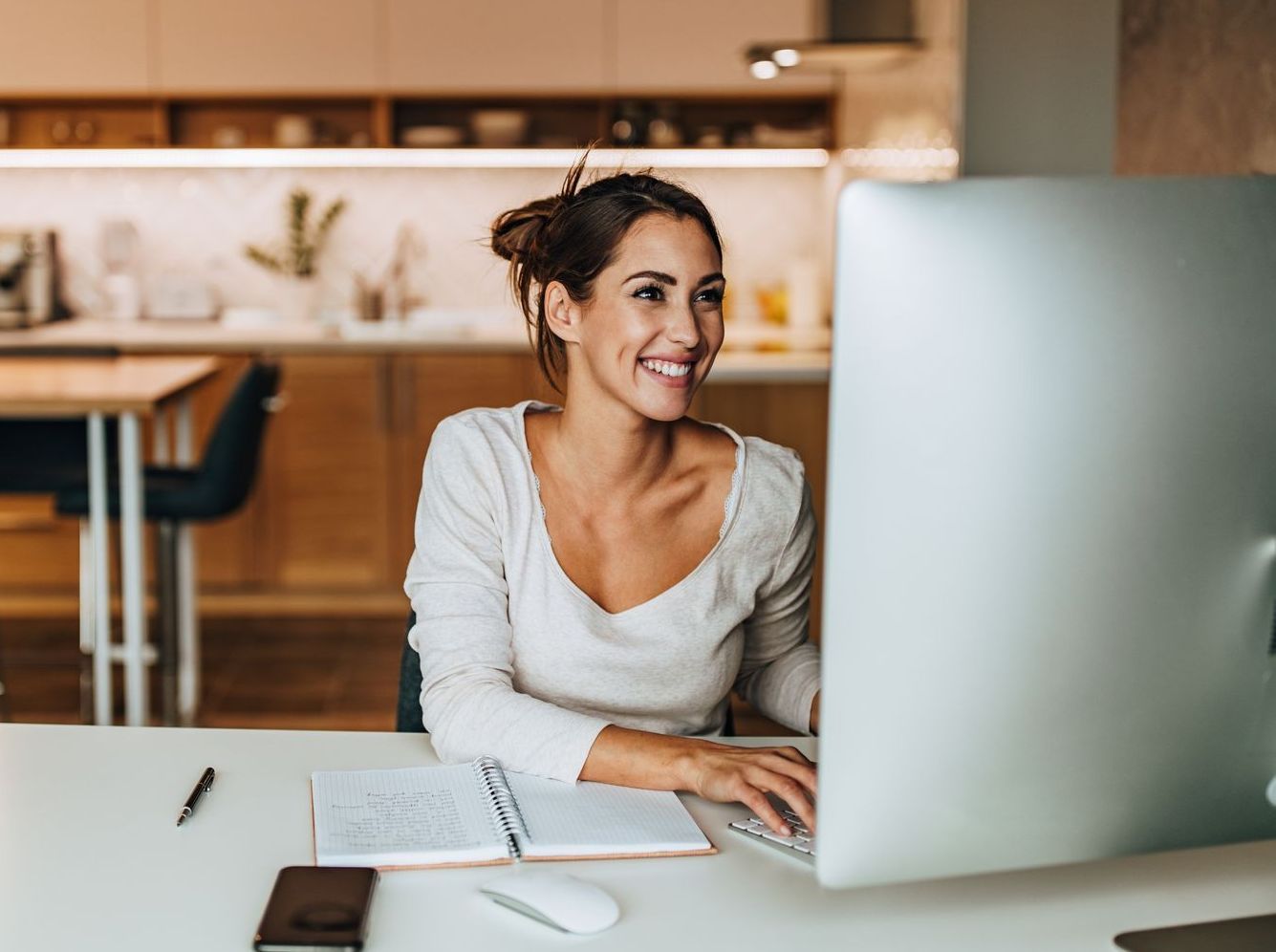 A woman is sitting at a desk in front of a computer.