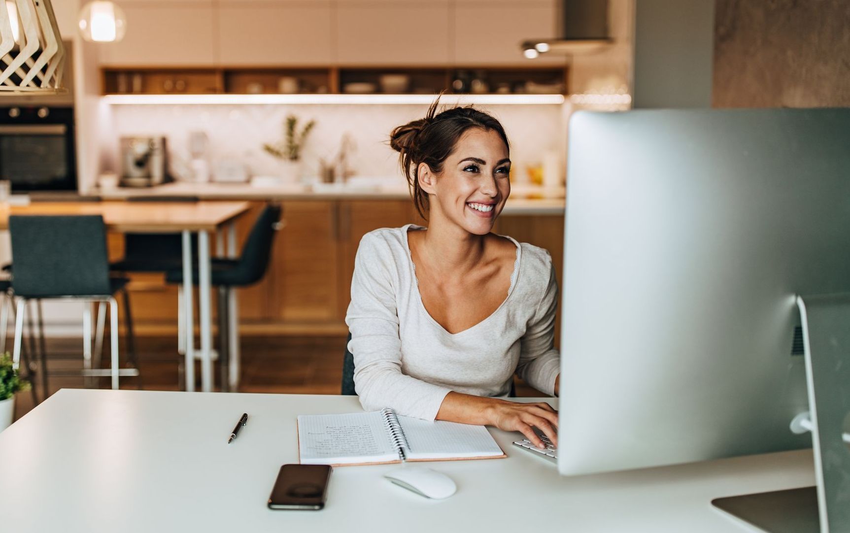 A woman is sitting at a desk in front of a computer.