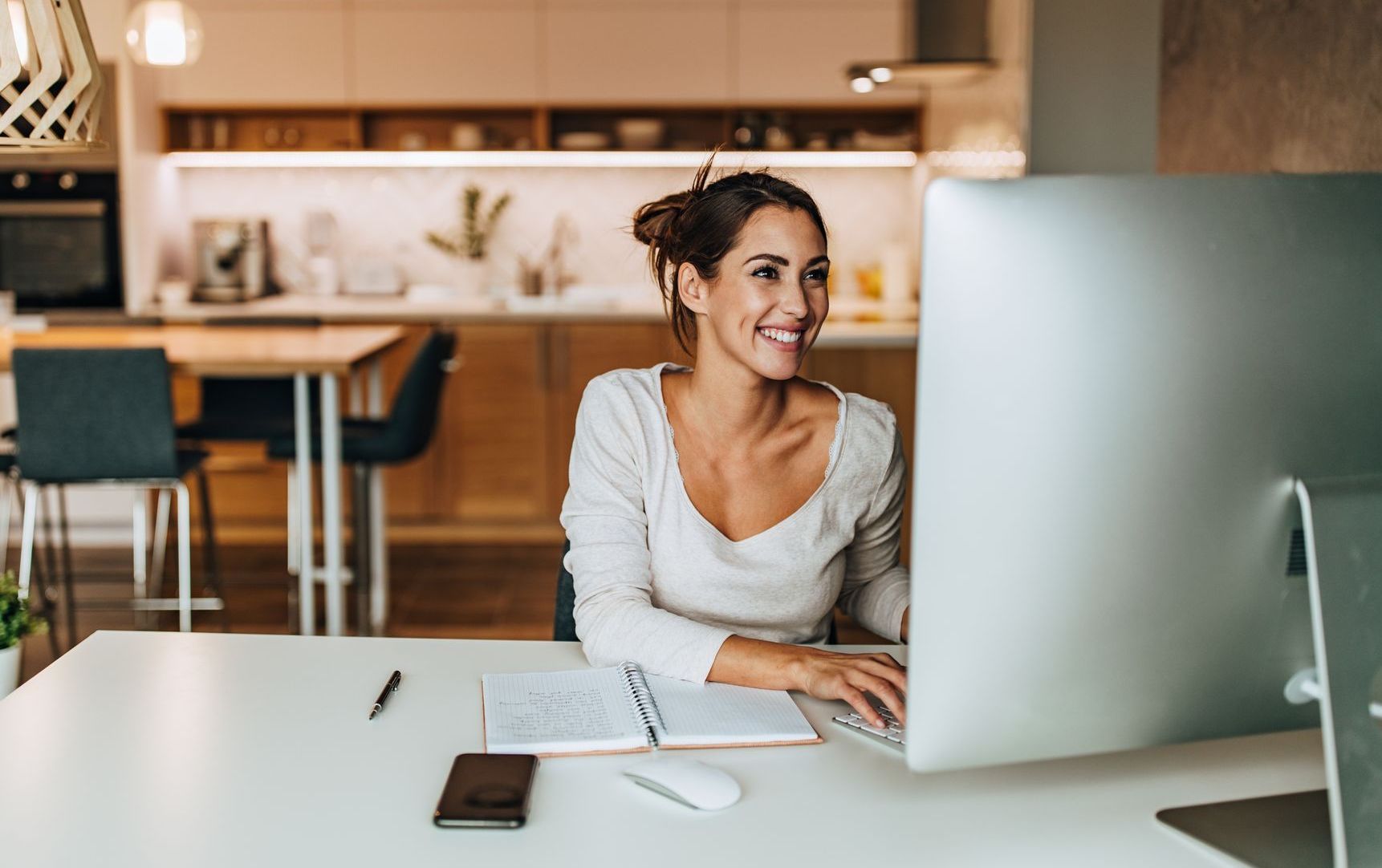 A woman is sitting at a desk in front of a computer.