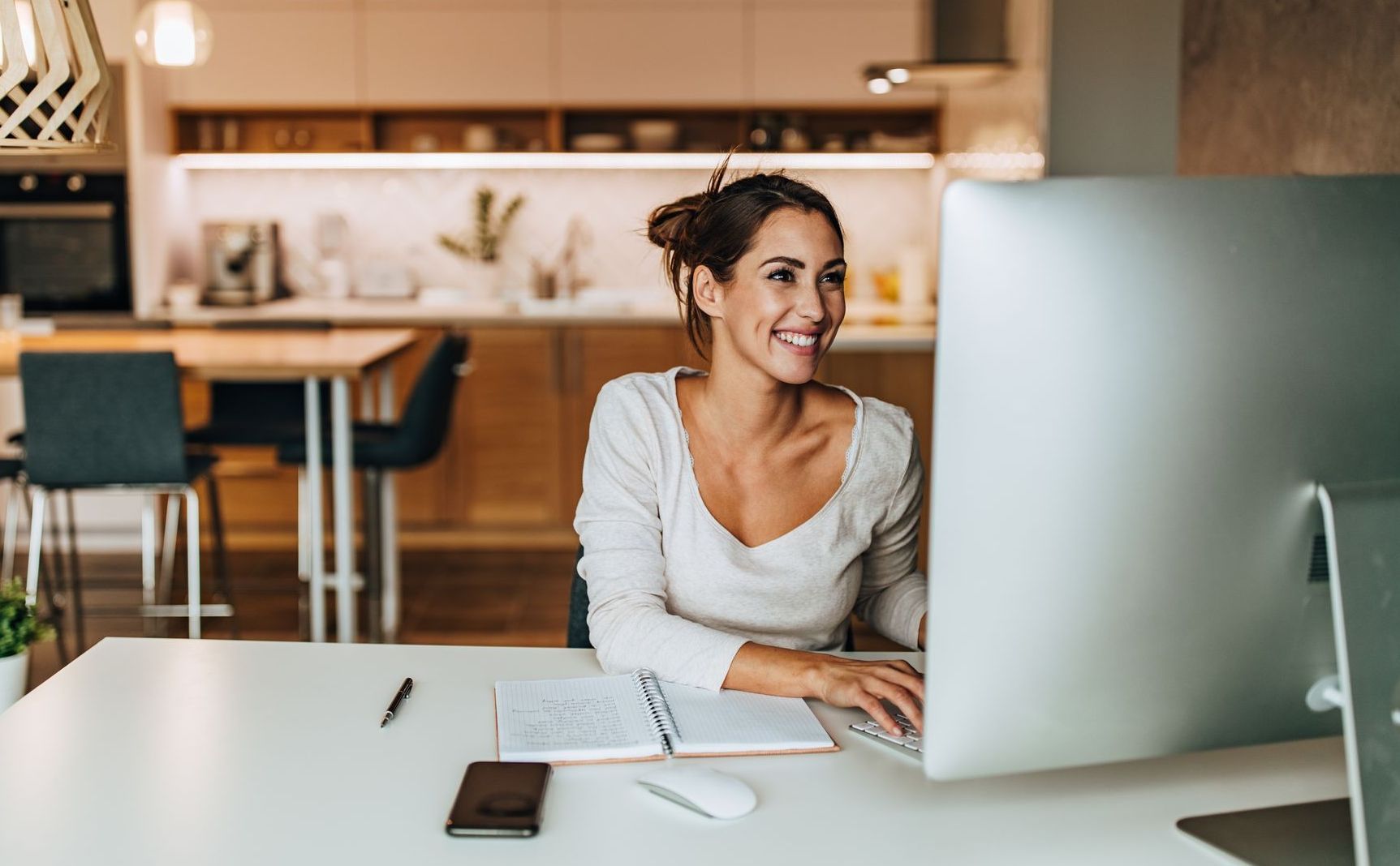 A woman is sitting at a desk in front of a computer.