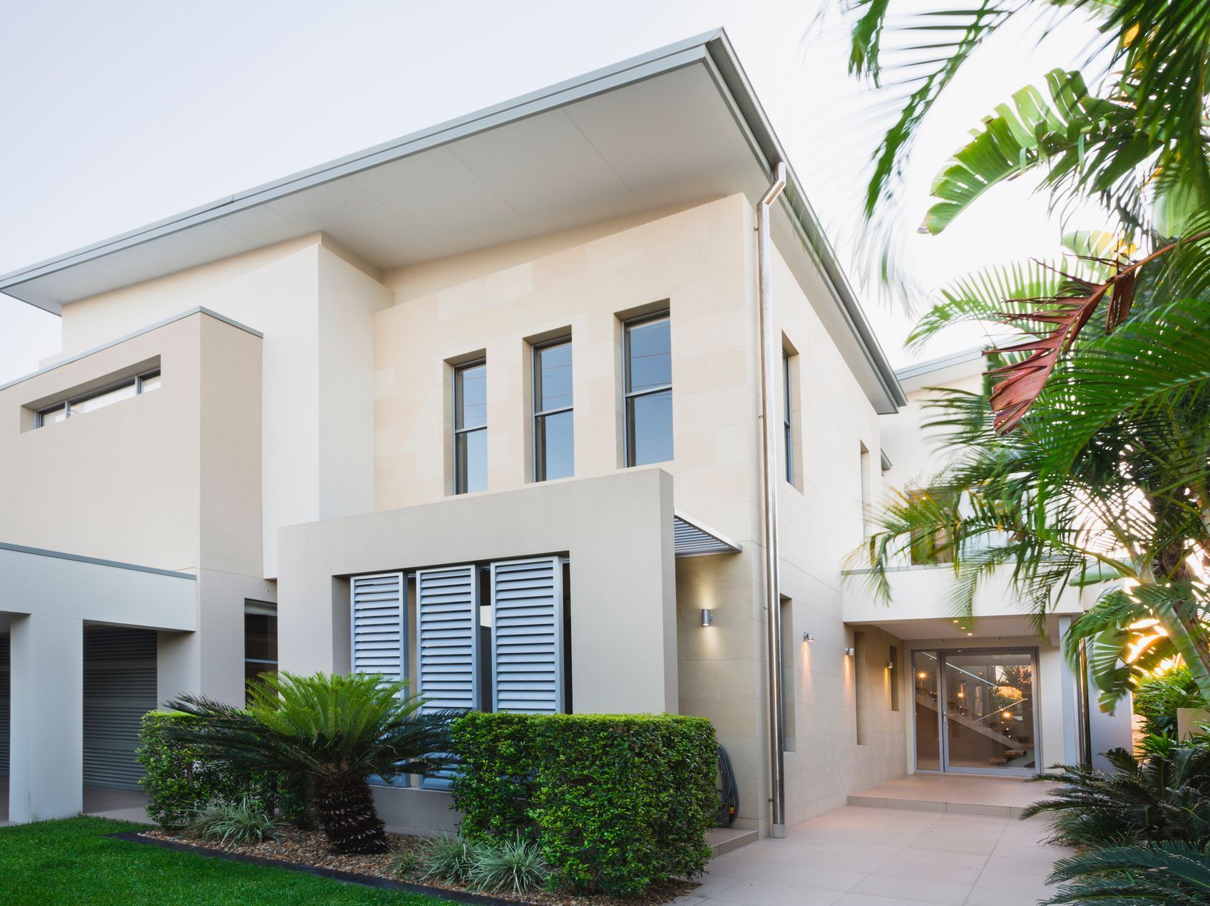 A large modern white house with a lot of windows.