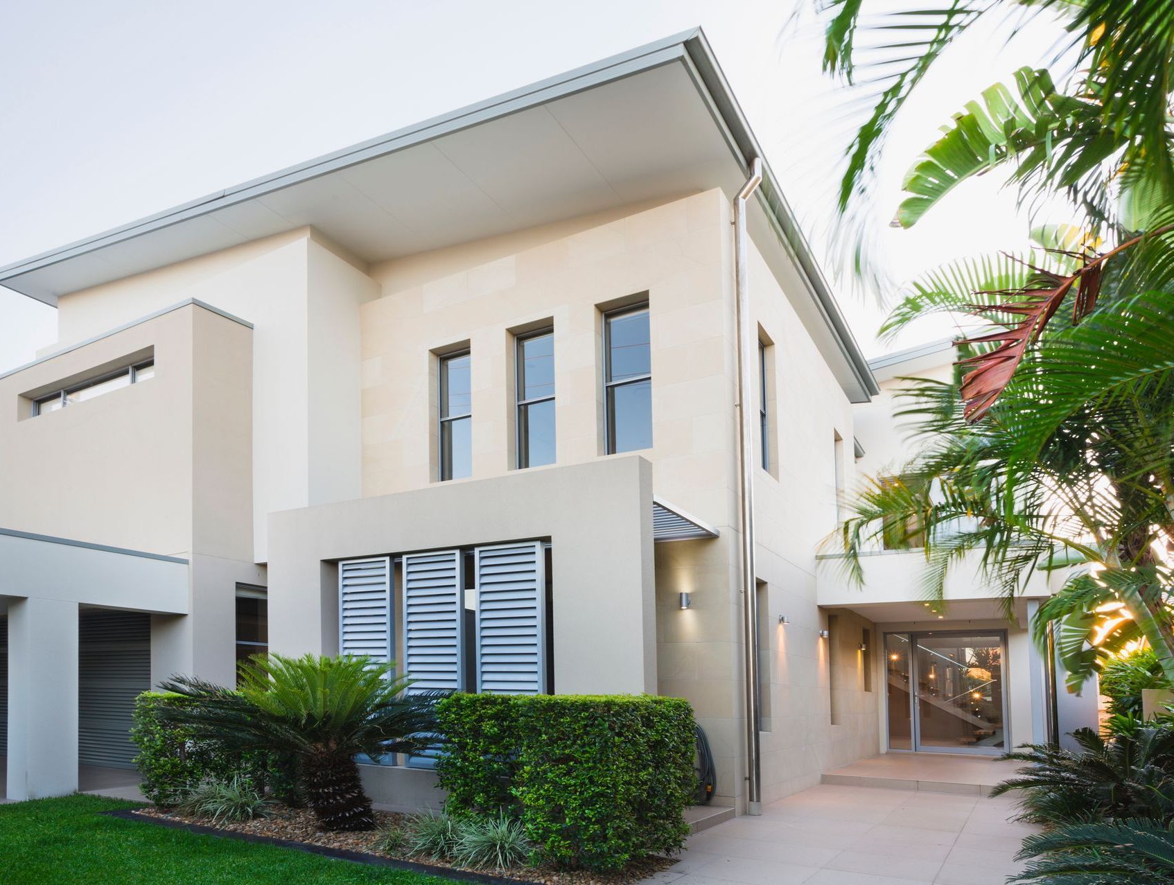 A large modern white house with a lot of windows.