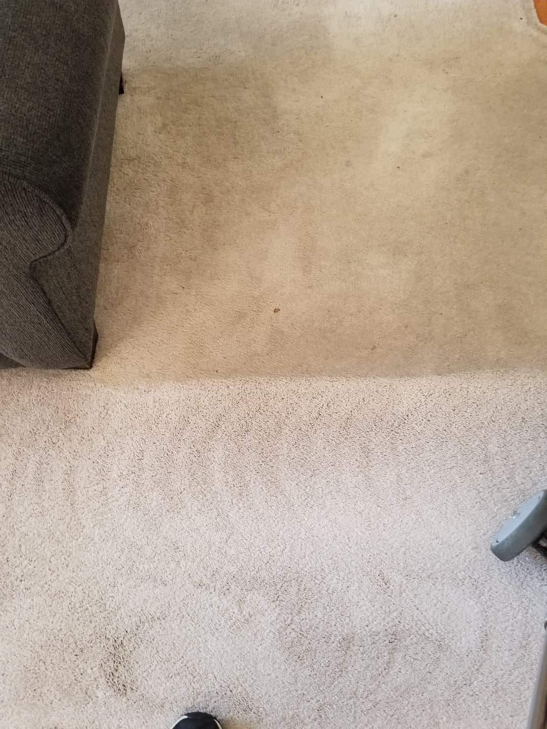 A carpeted floor in a living room with a couch and chair.