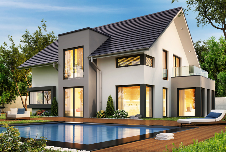 Modern two-story house with a pool and deck, surrounded by trees. Gray and white exterior with large windows.