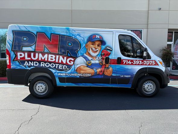 A side view of a white commercial van wrapped in blue graphics for PNR Plumbing, featuring a mascot and phone number.