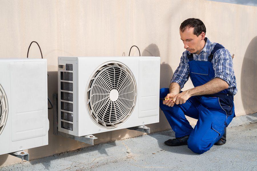 male worker doing air conditioner maintenance check up