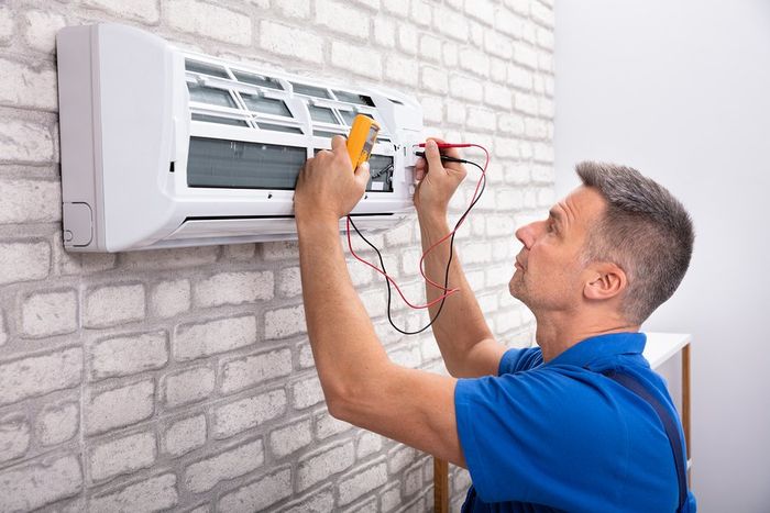 man checking the electrical system of air conditioner