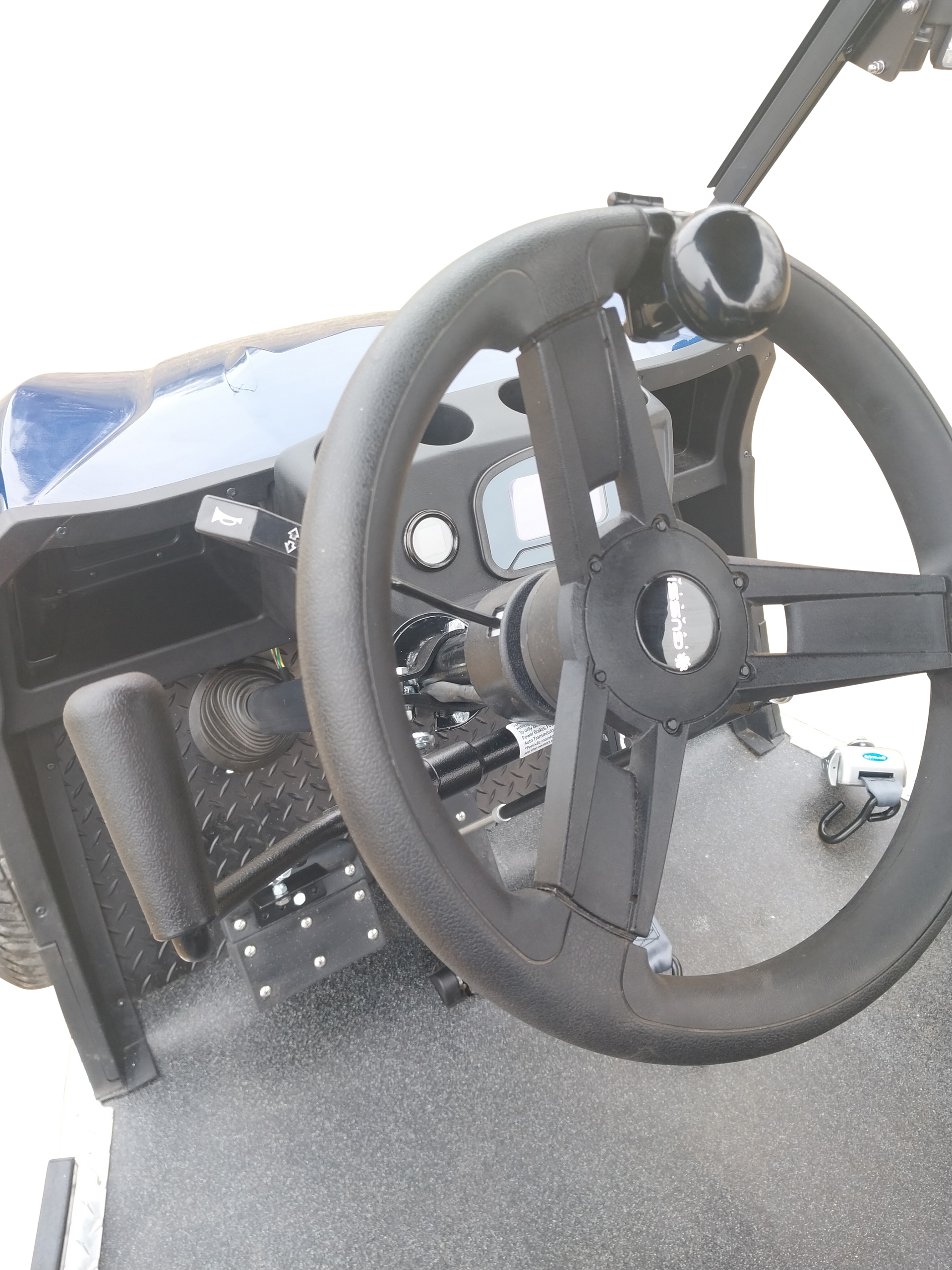 A close up of a steering wheel on a wheelchair golf cart from PHED Mobility - blue cart