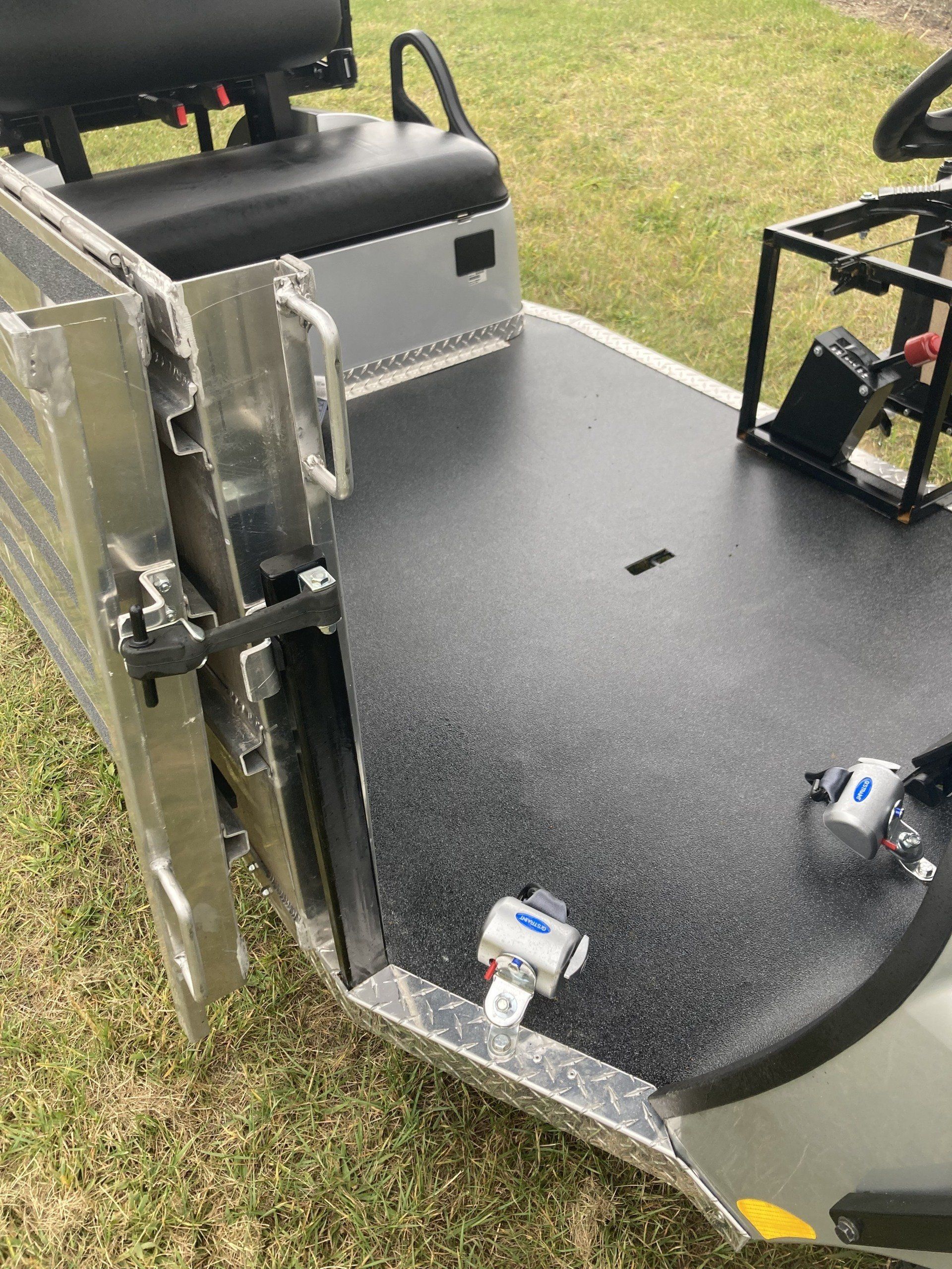 A golf cart is parked in the grass with the back door open.