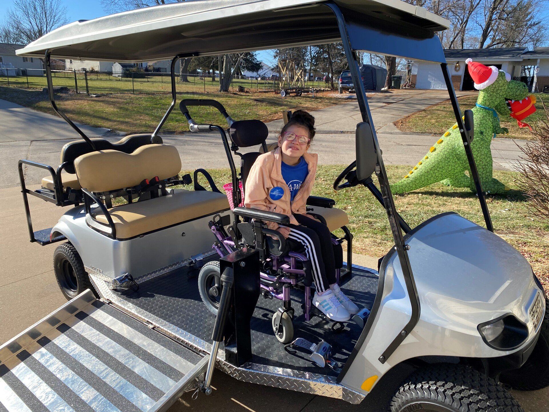 A woman in a wheelchair is sitting in a golf cart.
