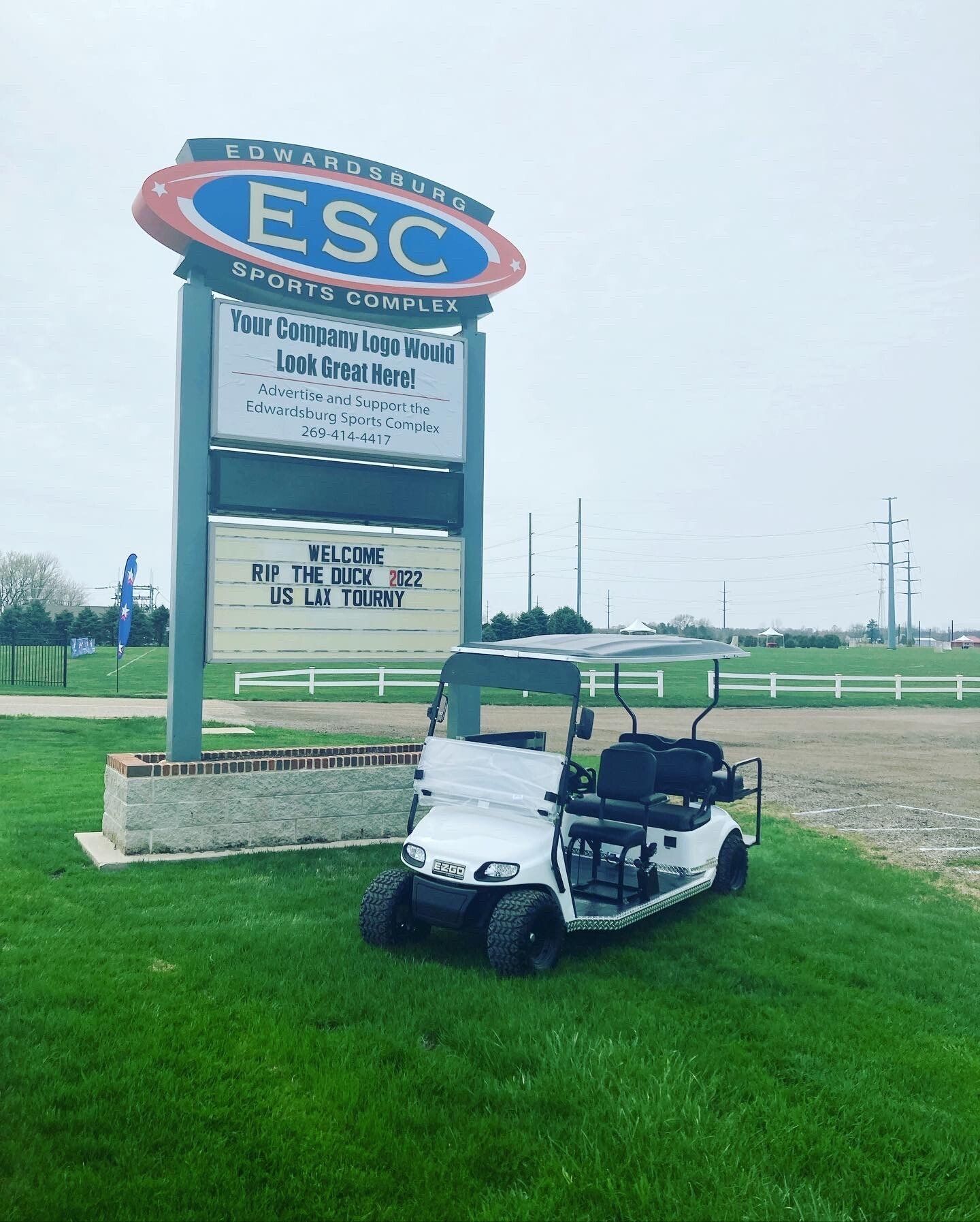 A golf cart is parked in front of a sign that says esc