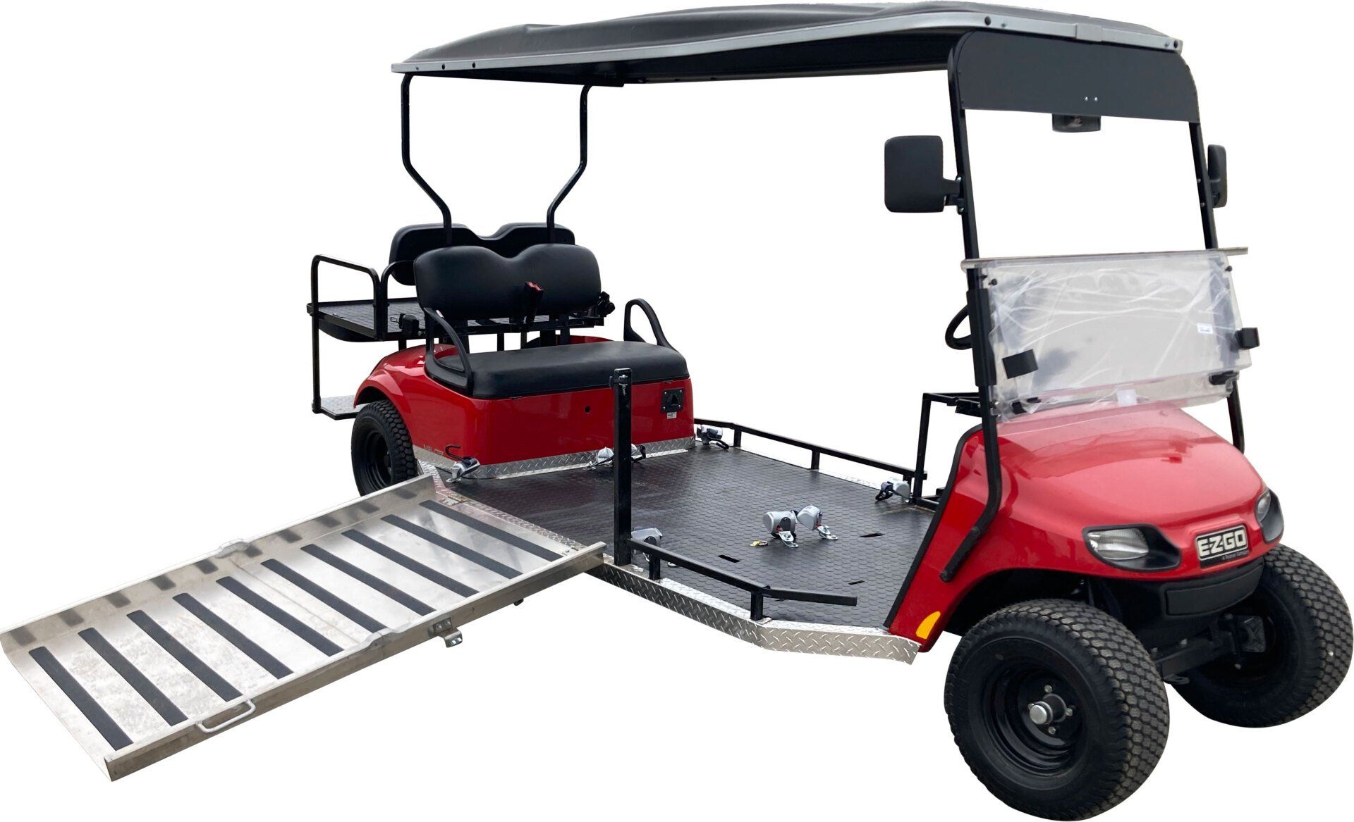 A red golf cart with a ramp attached to it.