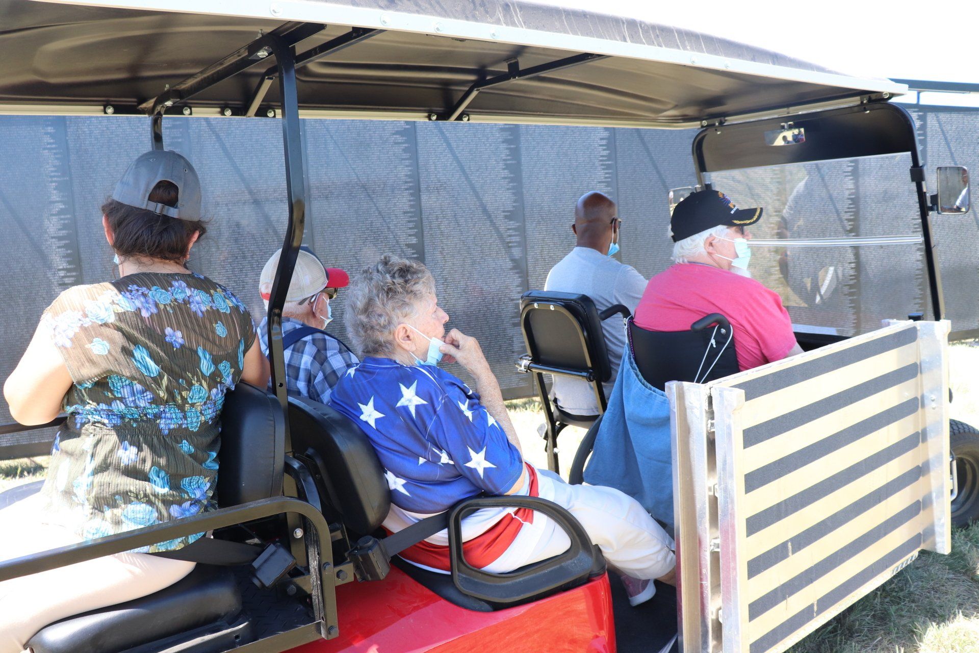 A group of people are sitting in a golf cart.