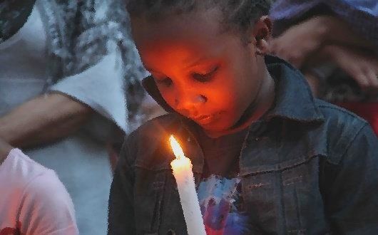 Young boy holds a candle